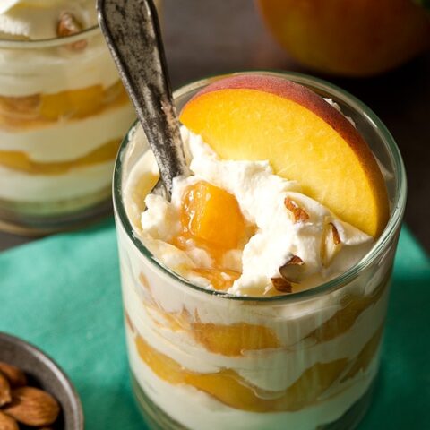 Peaches and cream cheese dessert layered as cheesecake parfaits