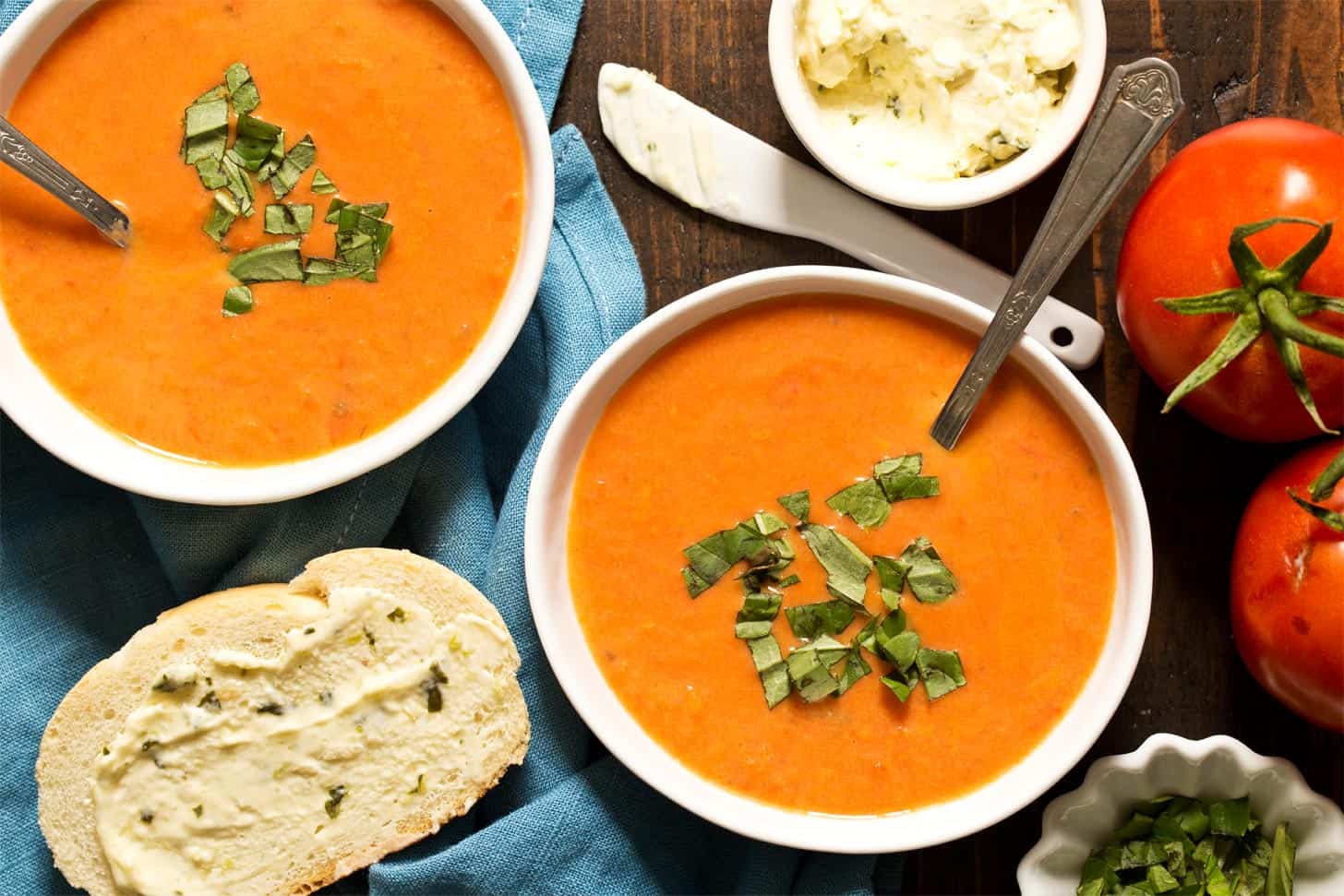 Creamy tomato soup with fresh tomatoes in white bowls