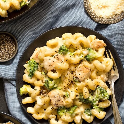 Alfredo mac and cheese on black plate with fork