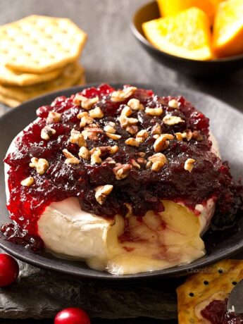 Cranberry Baked Brie oozing out onto a plate