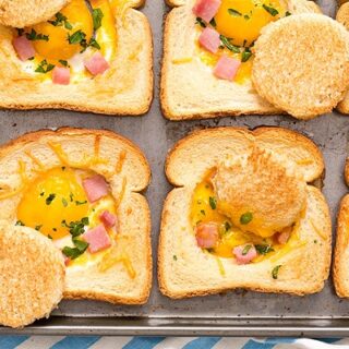 Close up of baked eggs in toast with ham and cheese