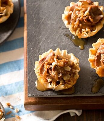 Looking for a bite-sized dessert to share with family and friends? These easy-to-serve No Bake Turtle Cheesecake Phyllo Cups with chocolate, caramel, and pecans will be a popular hit!