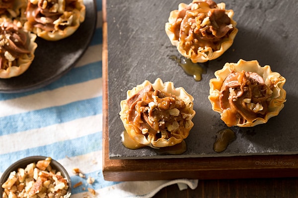 Looking for a bite-sized dessert to share with family and friends? These easy-to-serve No Bake Turtle Cheesecake Phyllo Cups with chocolate, caramel, and pecans will be a popular hit!