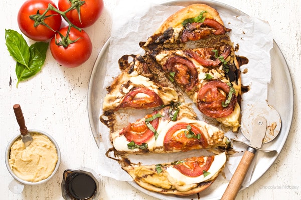Caprese Hummus Flatbread Pizza with fresh tomatoes, sliced mozzarella cheese, basil, and balsamic vinegar