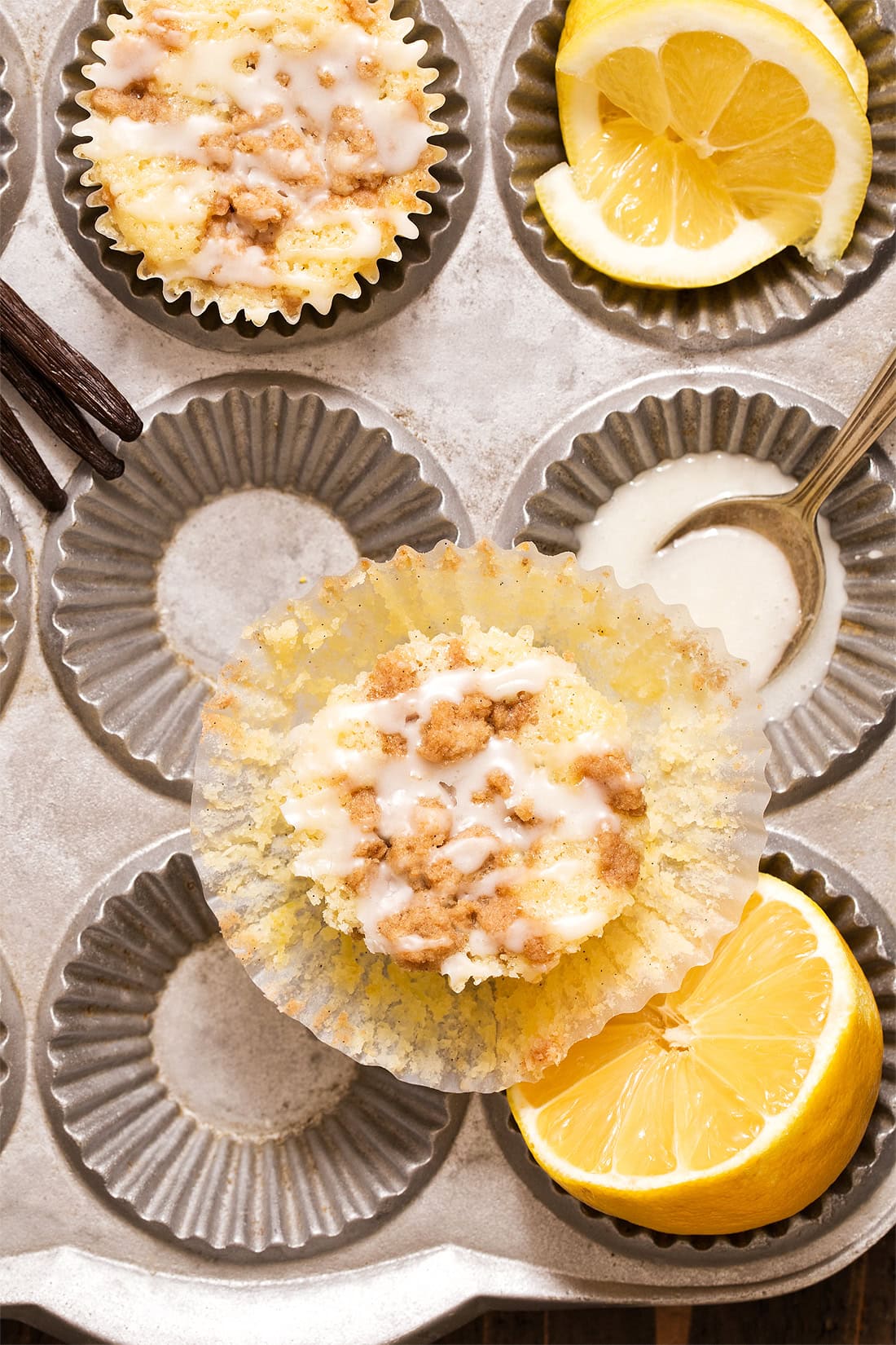 Unwrapped lemon crumble muffin with muffin pan