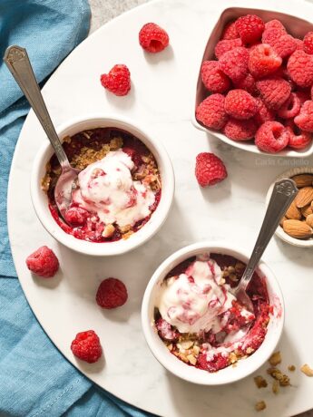 Enjoy a sweet ending to your day with mini Raspberry Almond Crisp For Two with a sweet and slightly tart raspberry filling topped with a crispy almond streusel baked in two ramekins.