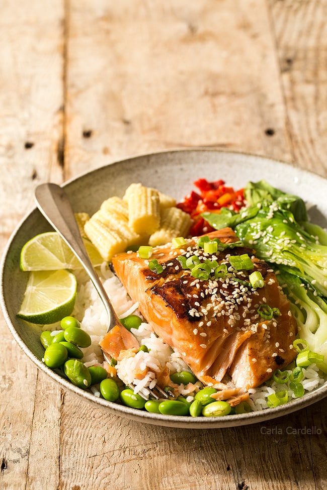 Asian Salmon with fork in bowl with vegetables and rice