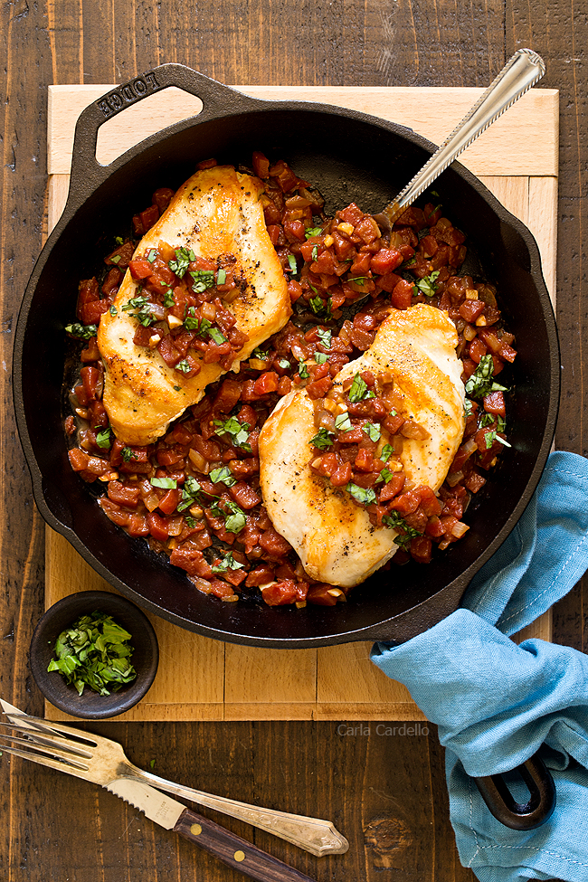 Chicken with tomatoes in cast iron skillet