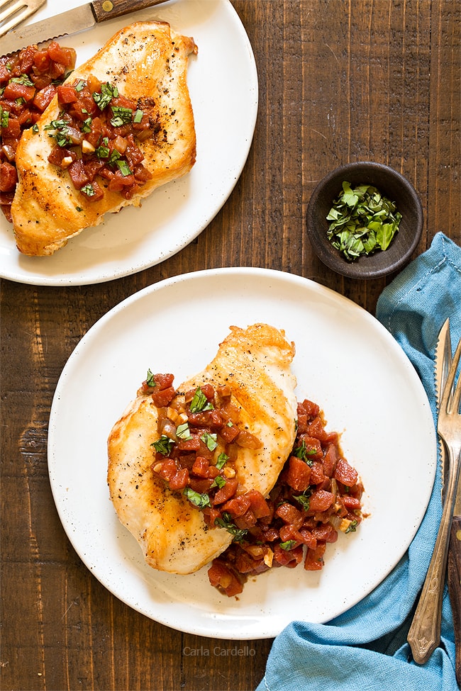 Chicken and tomatoes on white plate