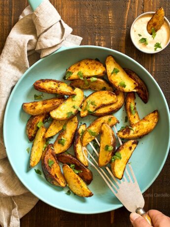 Hand serving fried potato wedges with spatula