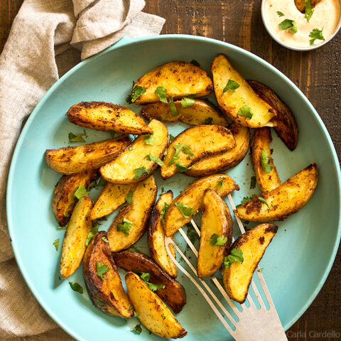 Hand serving fried potato wedges with spatula