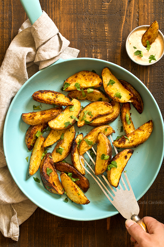 Hand serving fried potato wedges with spatula