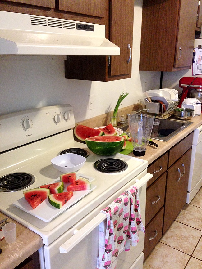 Cutting up watermelon in a small kitchen