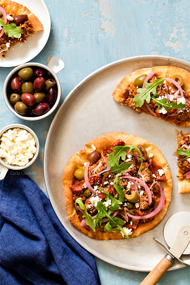 Put a Mediterranean twist on pizza night with Greek Pita Pizza! Top yours with ground lamb, olives, feta, pickled red onion, and arugula for an easy yet fulfilling meal.