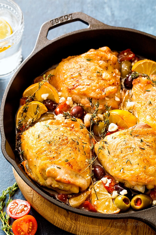 Chicken thighs in cast iron skillet with tomatoes and olives