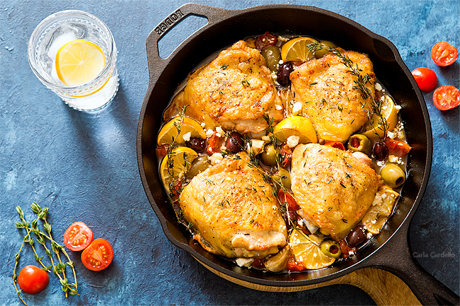 Chicken thighs in cast iron skillet with tomatoes and olives