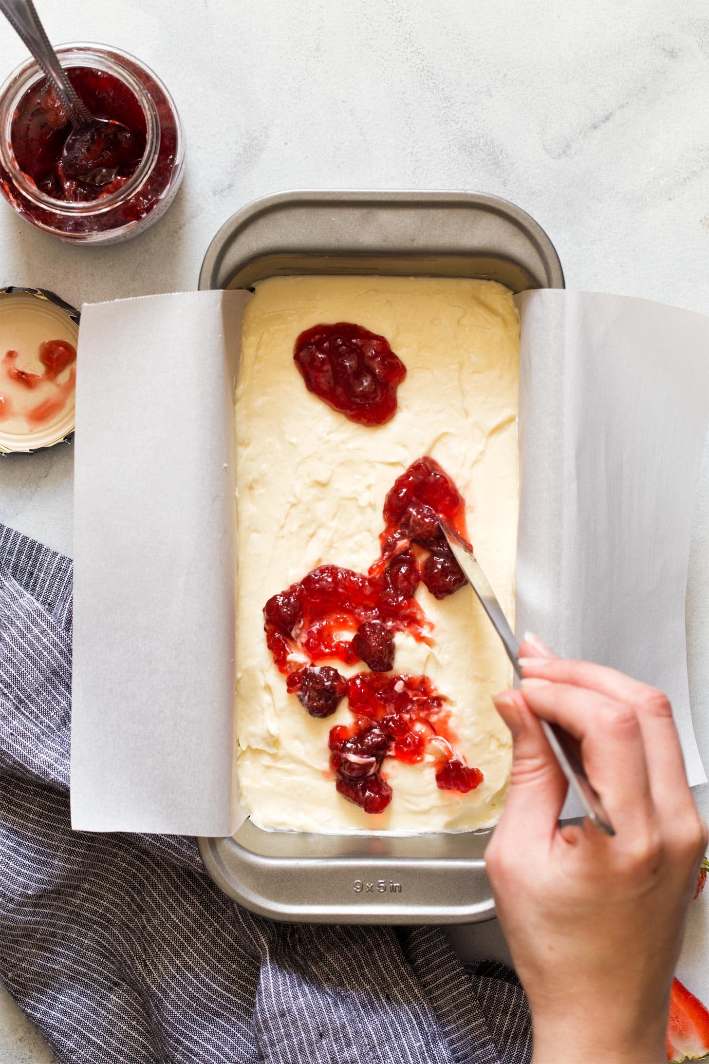 Swirling strawberry jam into cheesecake bars