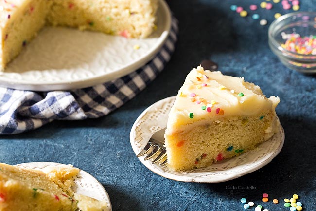 Slice of funfetti cake recipe on white plate