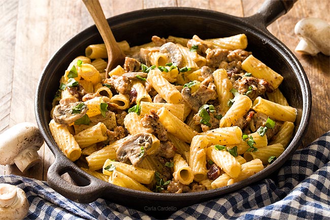 Italian Sausage Alfredo with mushrooms and rigatoni in cast iron pan