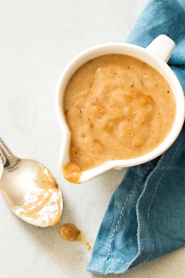 Gravy in white gravy bowl with spoon