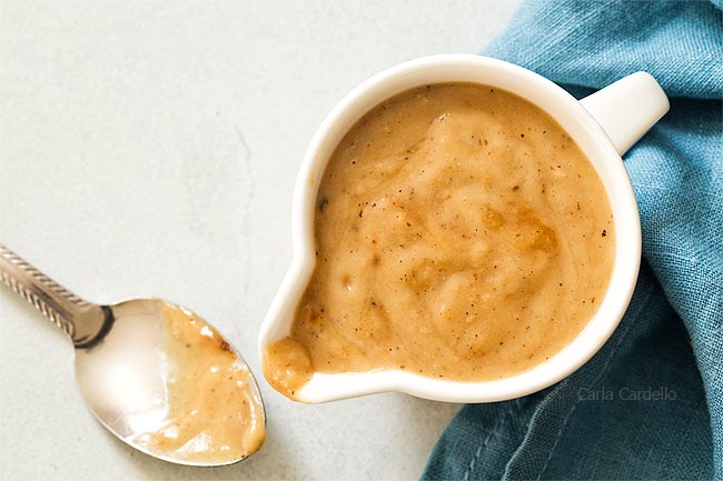 Gravy with spoon in white gravy bowl