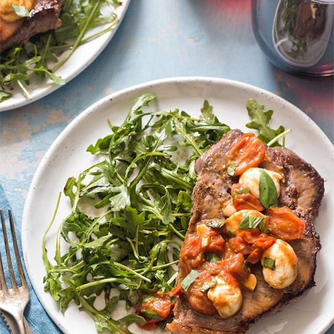 Steak dinner on plate with arugula salad