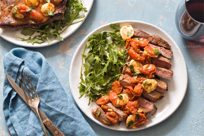 Sliced steak on plate with salad