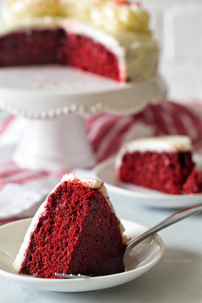 Slices of red velvet cake on white plates