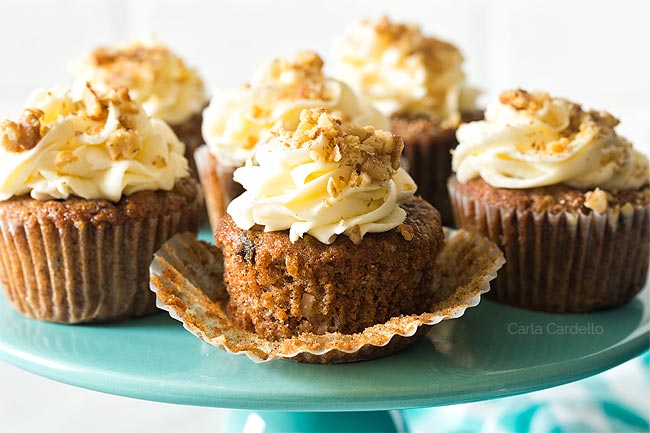 Unwrapped carrot cake cupcake on turquoise cake stand