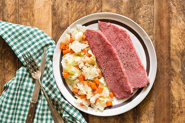 Corned Beef and Cabbage on brown plate with green napkin