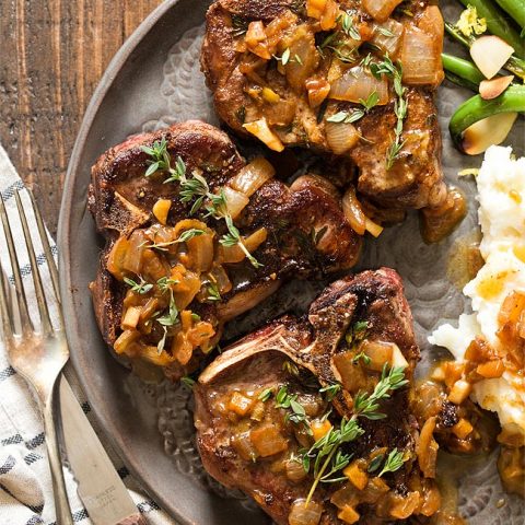 Pan fried lamb chops on gray plate