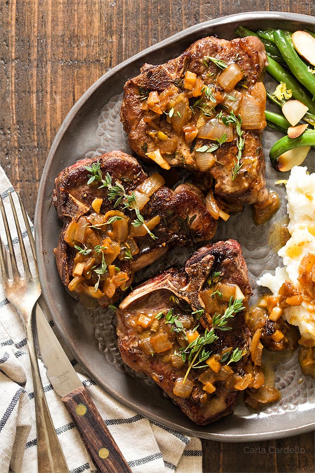 Pan fried lamb chops on gray plate