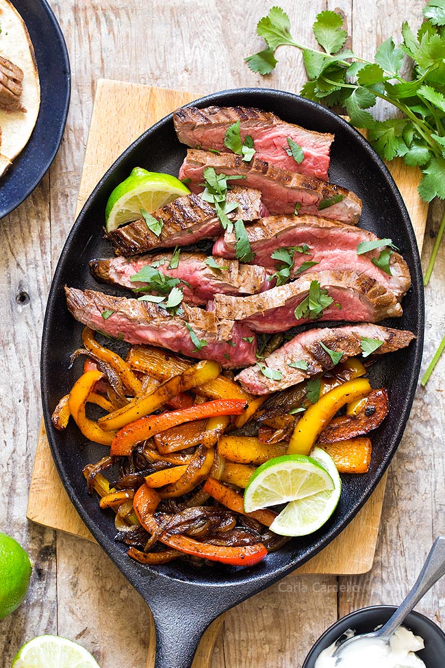 Close up steak fajita meat and peppers in cast iron pan