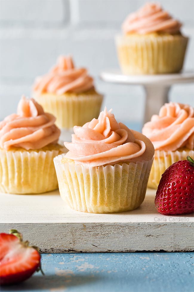 Group of vanilla cupcakes on white cutting board