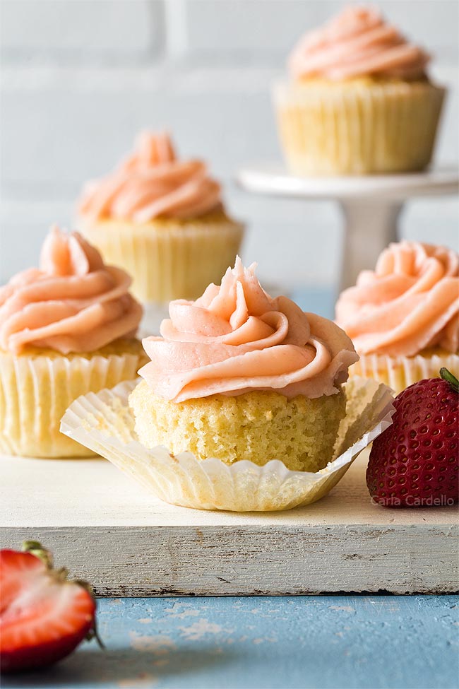 Group of vanilla cupcakes on white cutting board