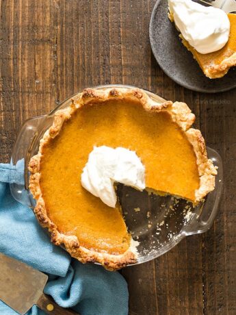 Small Pumpkin Pie in glass dish with slice missing