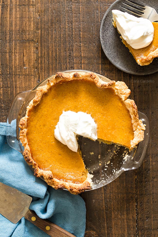 Small Pumpkin Pie in glass dish with slice missing