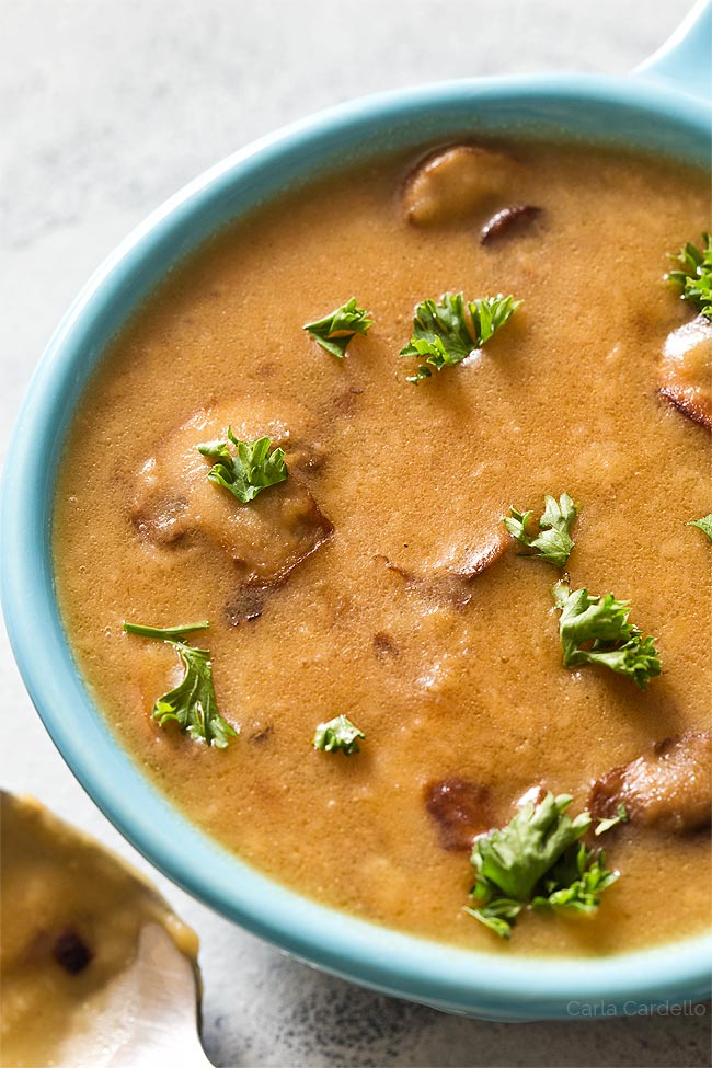 Close up of brown mushroom gravy in blue bowl