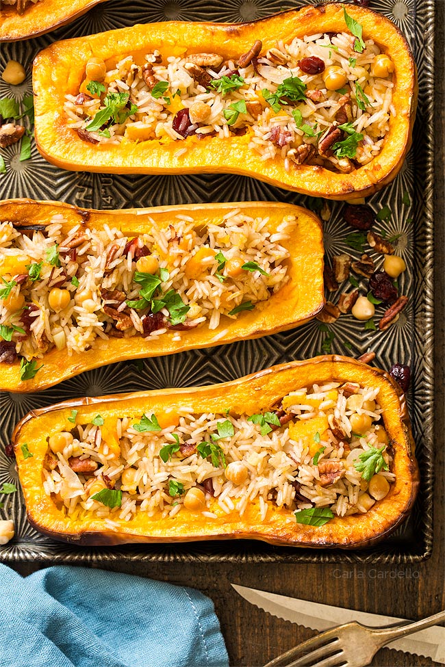 Three stuffed butternut squash halves on a baking sheet