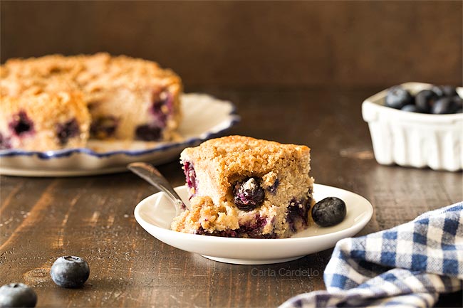 Slice of blueberry coffee cake with a bite taken 