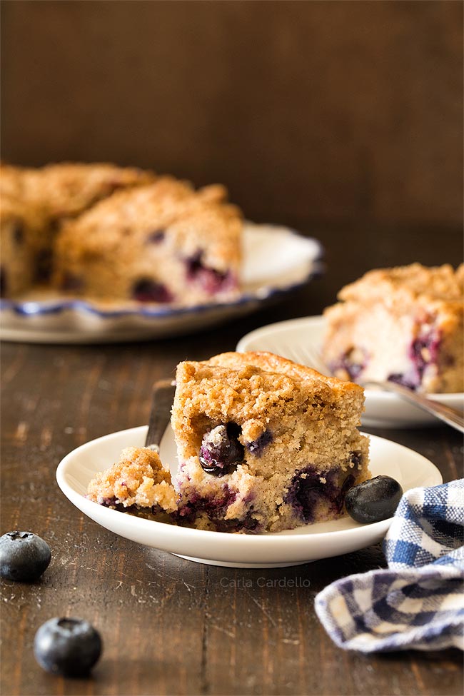 Slice of blueberry coffee cake with a bite taken 