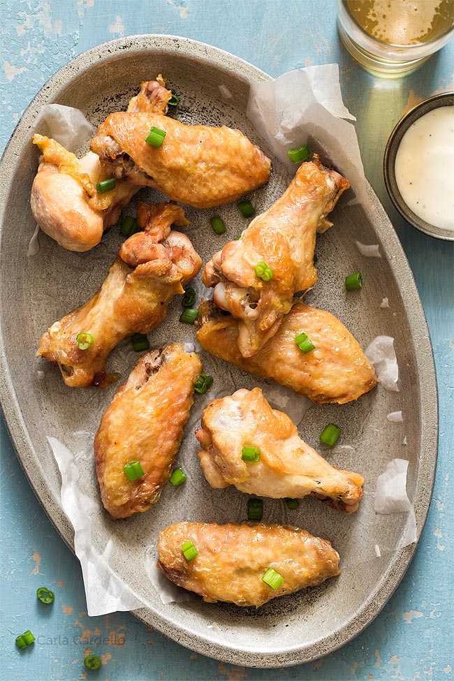 crispy wings on a silver plate with blue background