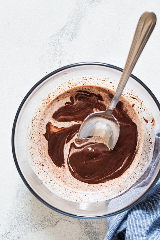 Stirring chocolate and cream together in glass bowl