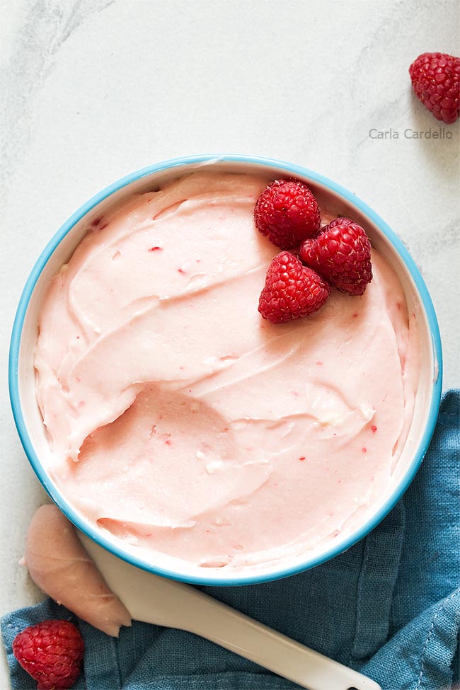 White bowl filled with pink raspberry cream cheese frosting