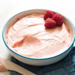 Raspberry cream cheese frosting in white bowl