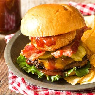 BBQ burgers in a plate with chips and red checked napkin