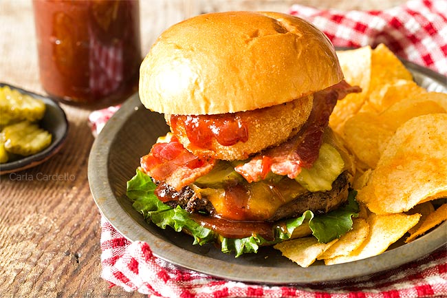 BBQ burgers in a plate with chips and red checked napkin