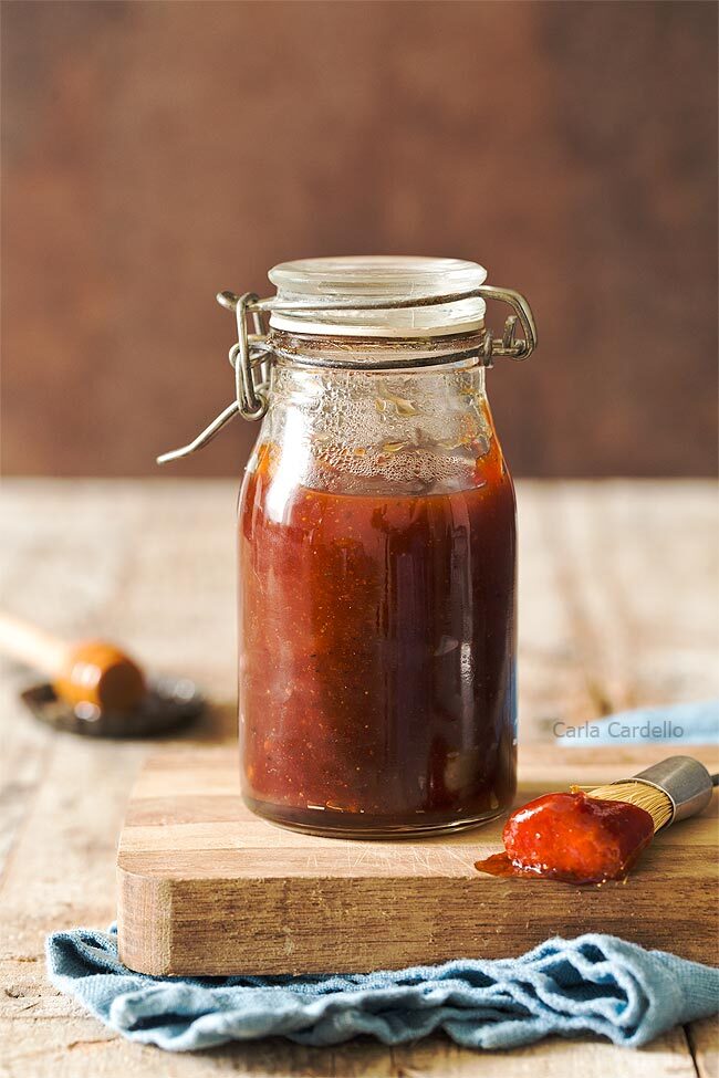Jar of honey bbq sauce on a cutting board