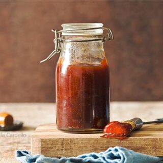 Jar of honey bbq sauce on a cutting board
