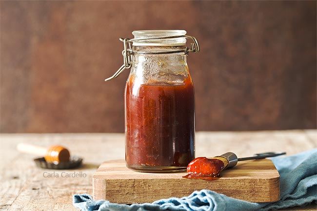 Jar of honey bbq sauce on a cutting board